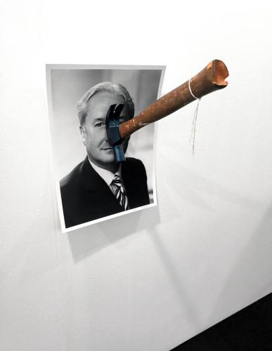 Prayer - Photograph of the artist's Grandfather and hammer held to wall by nail, with artist's Father's nose milled into handle at nose height while kneeling - Photosculpture - 2019